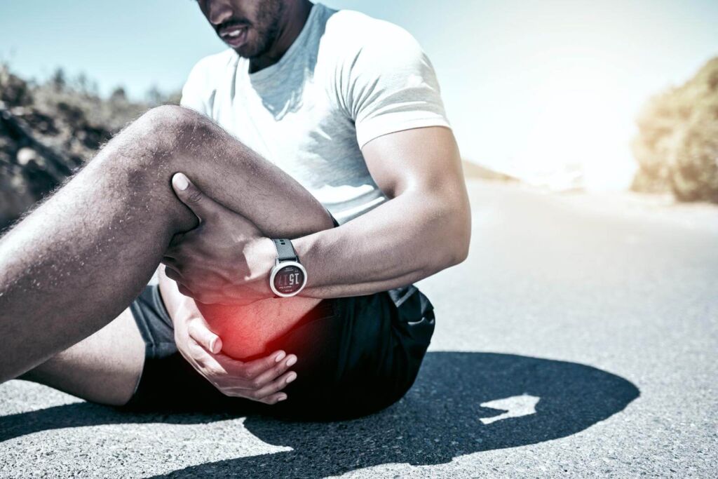 how long do i need to train for a marathon - man holding his leg in pain while exercising outdoors