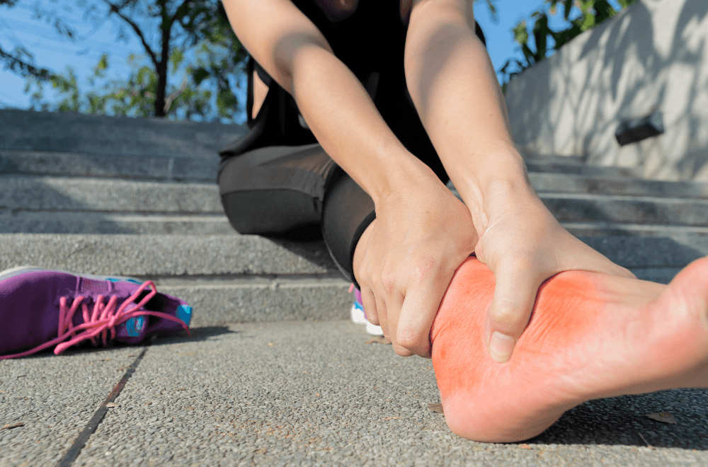 Woman holding her red foot