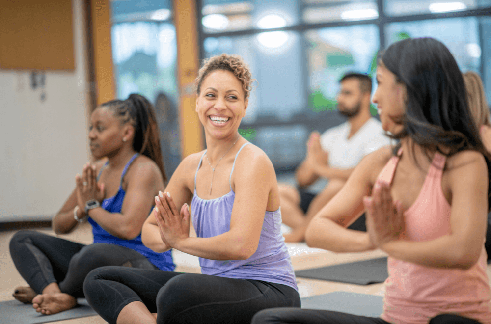 Women smiling at each other in yoga class
