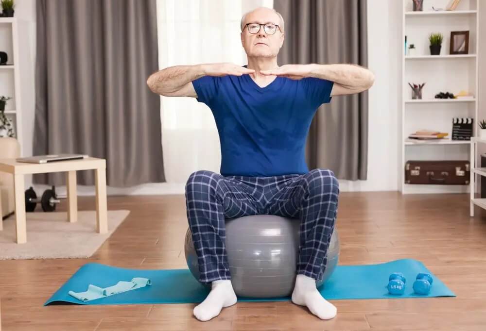 Old man doing yoga on a yoga ball